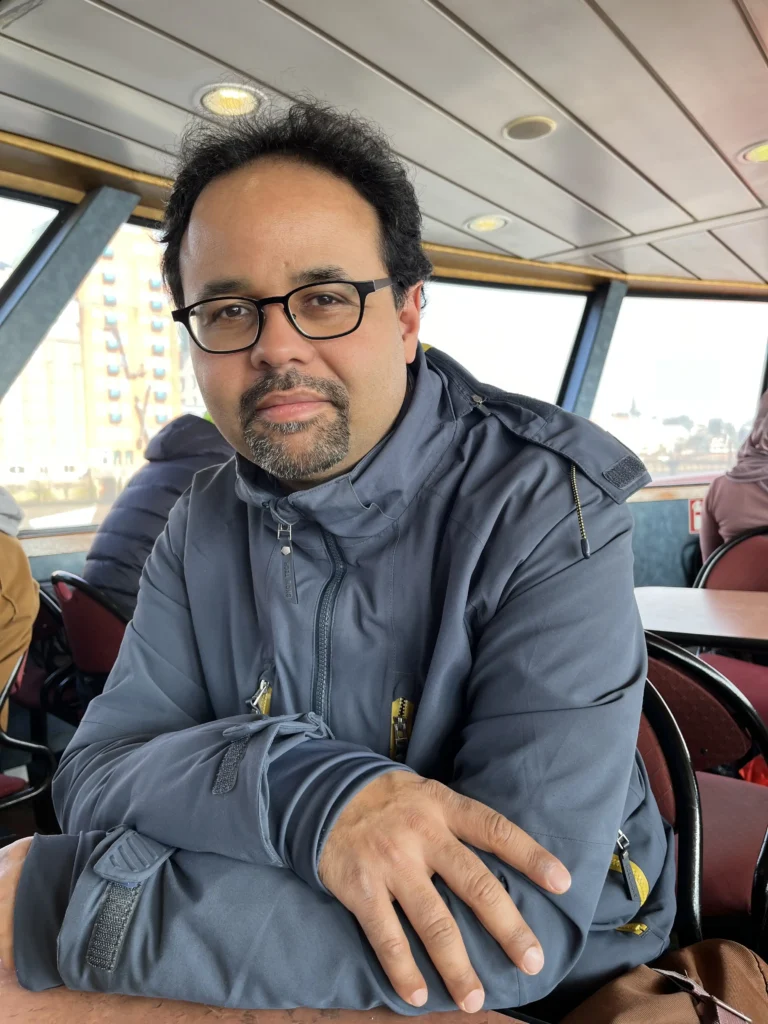 Thierno Bah ist auf einem Schiff, und lächelt in die Kamera.